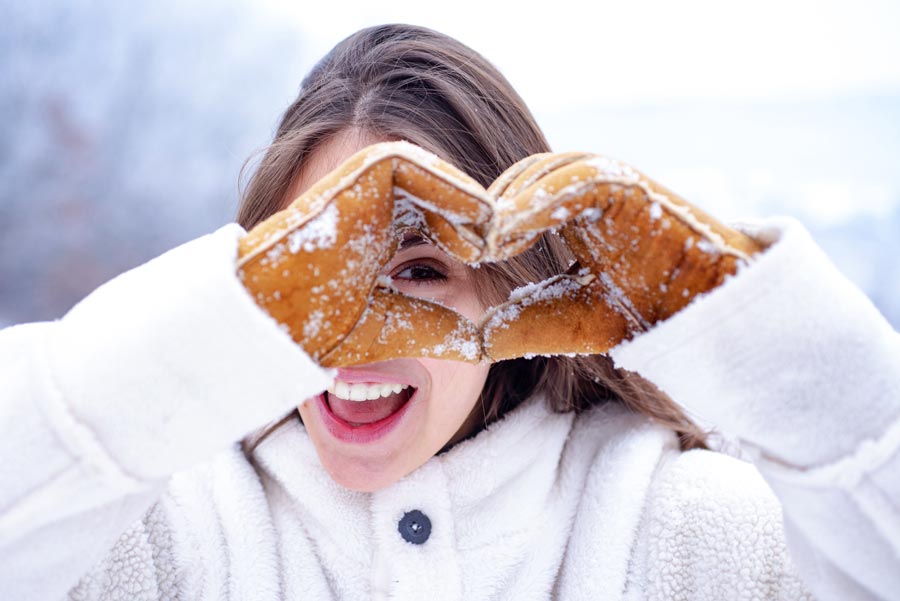 Woman in snow holding a heart